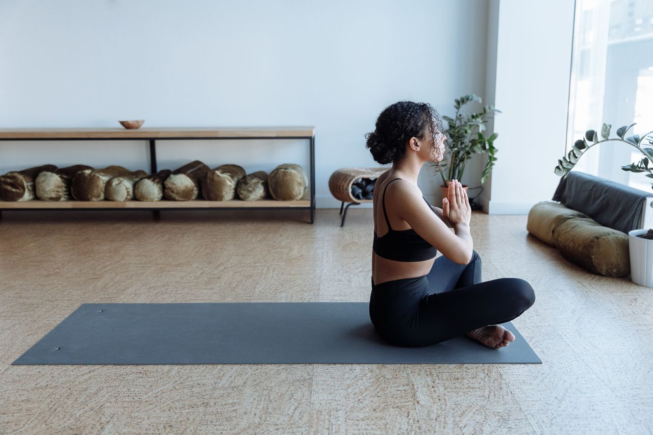 An African American woman meditating in a yoga studio, embracing wellness and balance.